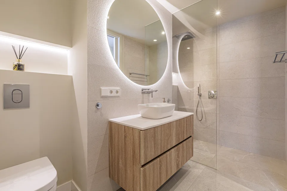 Fotografía de alquiler vacacional de un moderno baño con lavabo sobre mueble de madera y ducha a ras de suelo en Nueva Andalucía