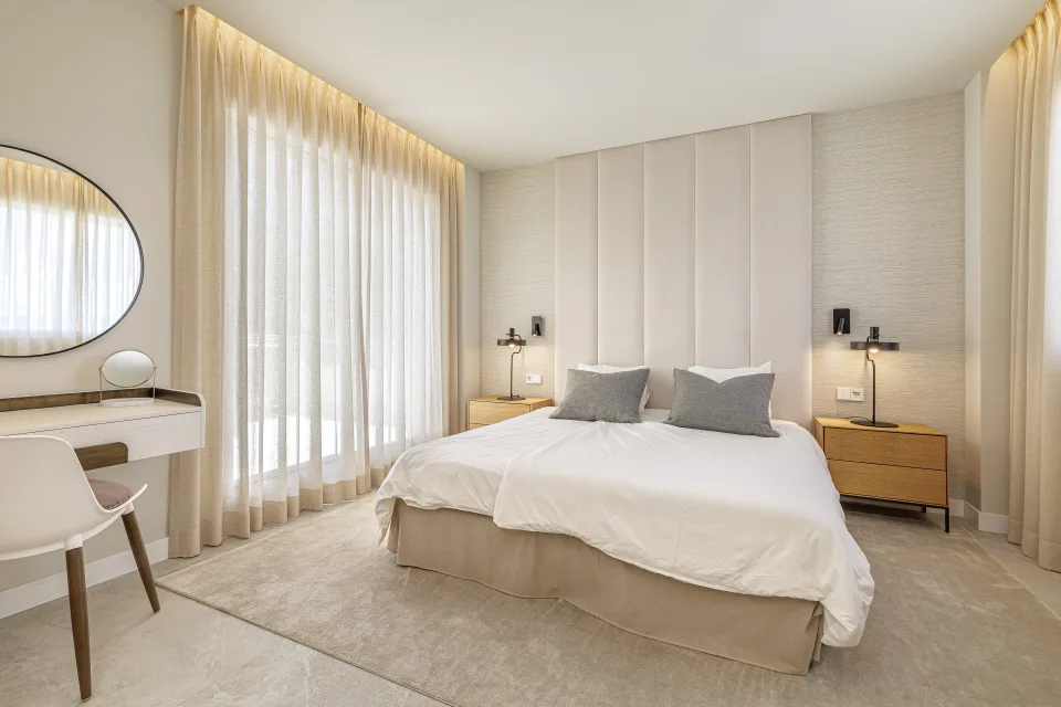 Fotografía de alquiler vacacional de un dormitorio luminoso con cama king size, mesitas de noche y ventanas amplias en Nueva Andalucía