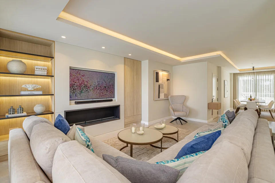 Vacation rental photograph of a modern living room with beige sofa, circular coffee table and unit with TV in Nueva Andalucía