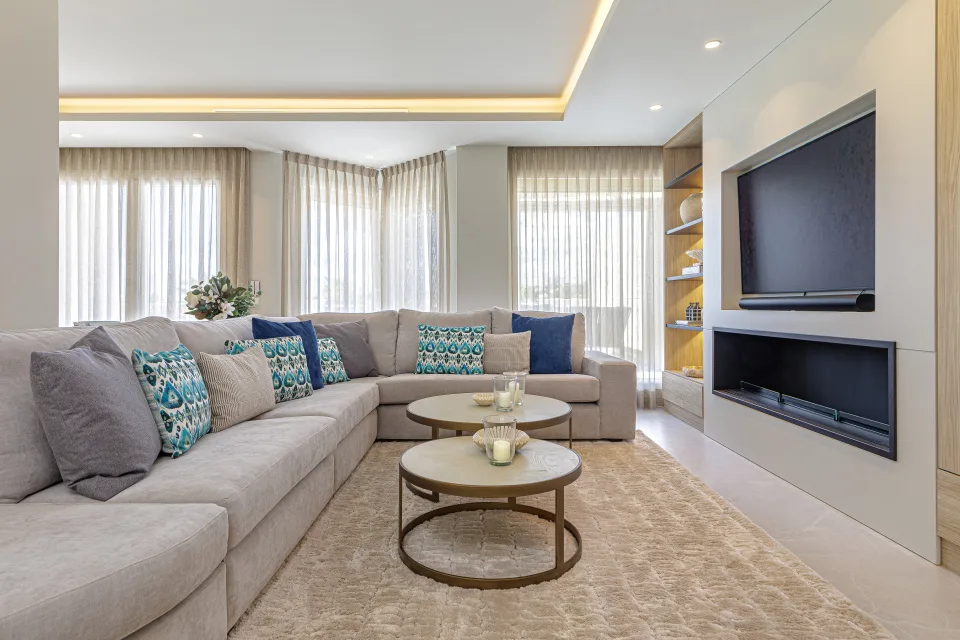 Vacation rental photograph of a spacious living room with comfortable sofas, decorative cushions, and a circular coffee table in Nueva Andalucía