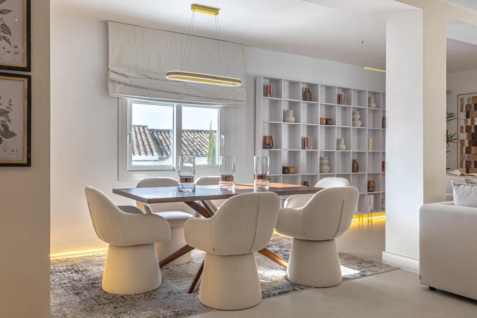 Fotografía de interiorismo y arquitectura de un comedor moderno con mesa de madera, sillas acolchadas en Cala de Mijas