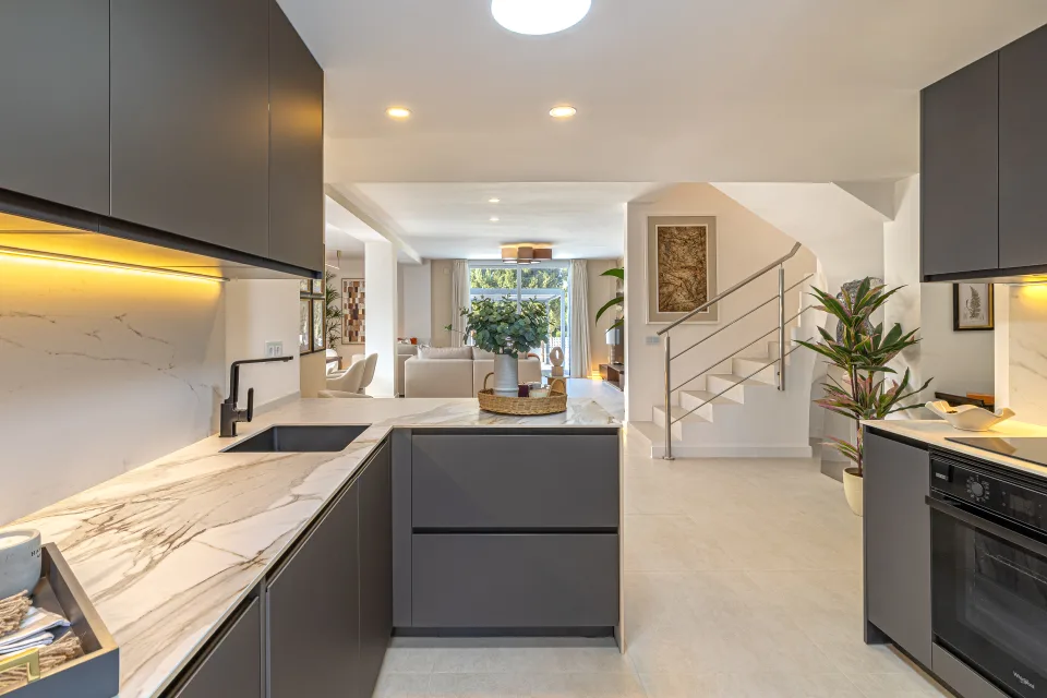 Interior design and architecture photograph of a modern kitchen with dark cabinetry, marble countertops in Cala de Mijas