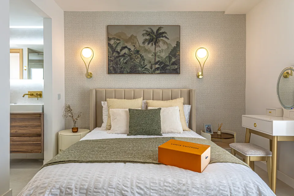 Interior design and architecture photograph of a bright bedroom with a padded headboard, wall lamps and contemporary decor in Cala de Mijas
