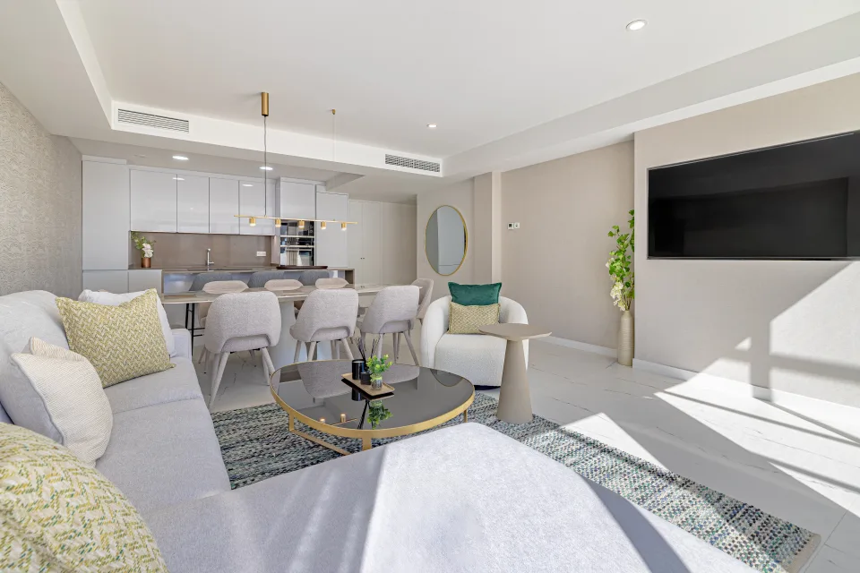 Vacation rental photograph of a bright living room with light sofa, circular coffee table and modern dining area in Casares Costa