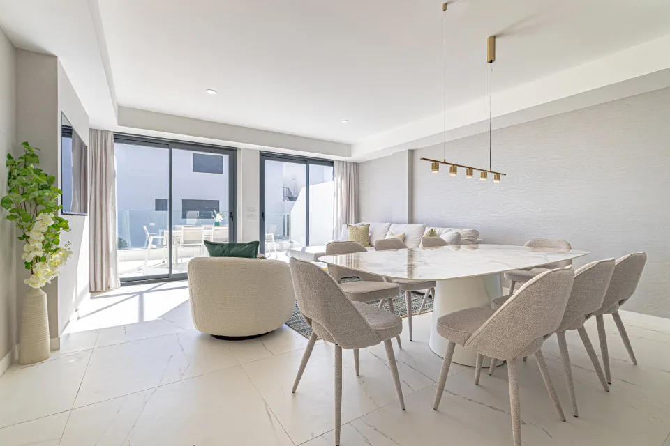 Vacation rental photograph of a modern dining area with a large table, designer chairs, and access to a bright terrace in Casares Costa
