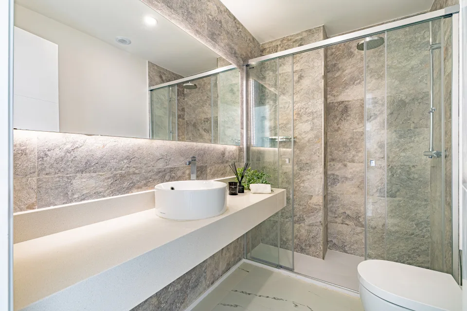 Vacation rental photograph of a modern bathroom with ceramic sink on stone countertop and walk-in shower in Casares Costa