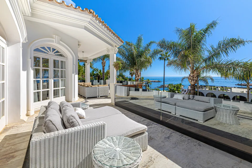 Fotografía de alquiler vacacional de un elegante salón exterior con cómodos sofás de mimbre y vistas al mar en Marbella
