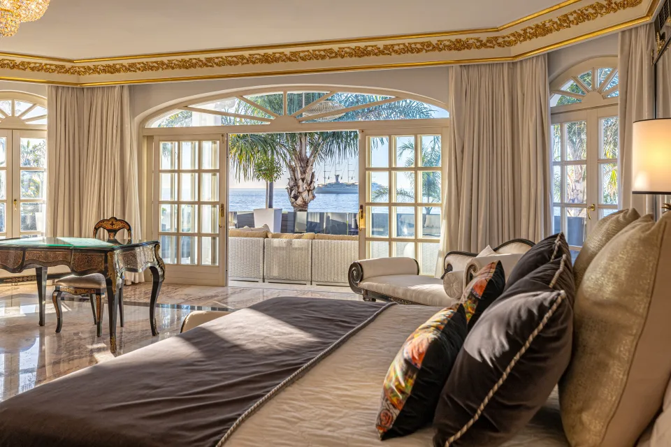Fotografía de alquiler vacacional de un elegante dormitorio con vistas al jardín, luz natural y mobiliario clásico en Marbella