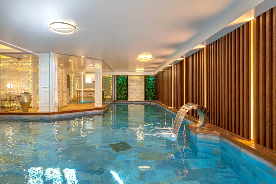 Fotografía de alquiler vacacional de un elegante spa interior con piscina climatizada y detalles de madera en Marbella