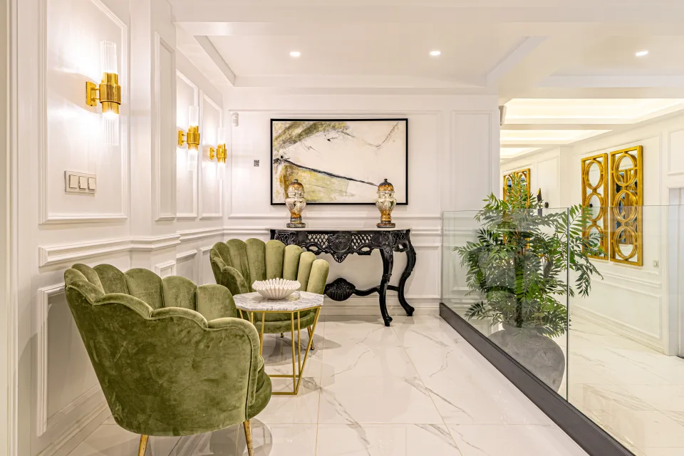 Fotografía de alquiler vacacional de un elegante salón con sillones verdes, mesa de café y decoraciones artísticas en Marbella