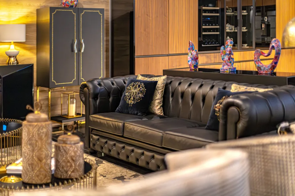 Fotografía de alquiler vacacional de una elegante sala de estar con un sofá de cuero negro, cojines decorativos y muebles de diseño en Marbella