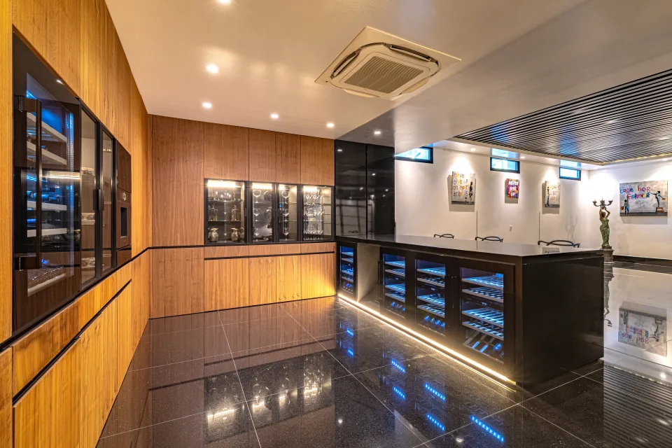 Fotografía de alquiler vacacional de un elegante espacio interior con barra, iluminación suave y vitrinas de exhibición en Marbella
