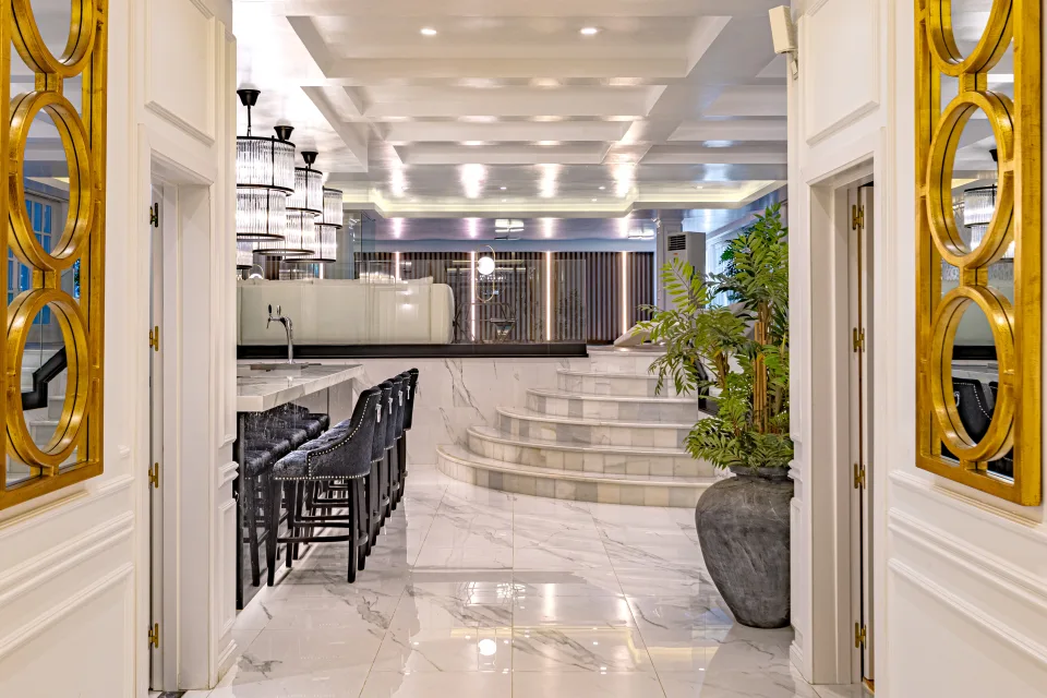 Fotografía de alquiler vacacional de un elegante vestíbulo con mármol brillante, bar con taburetes oscuros y escaleras adicionales en Marbella
