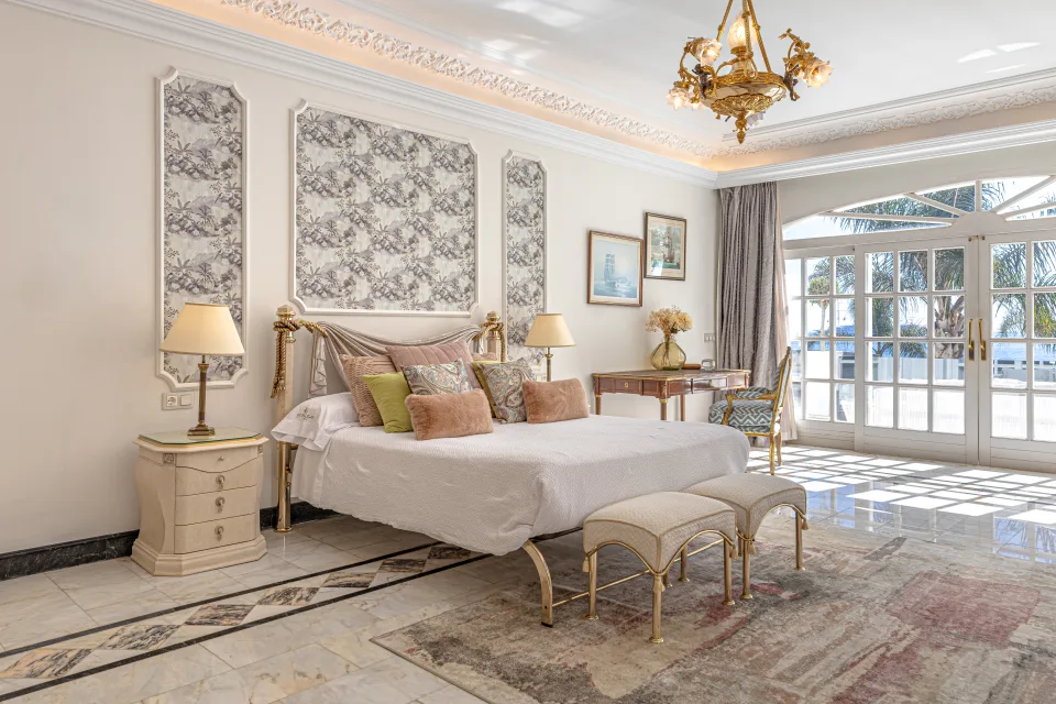 Fotografía de alquiler vacacional de un elegante dormitorio con cama doble, lámparas a ambos lados en Marbella