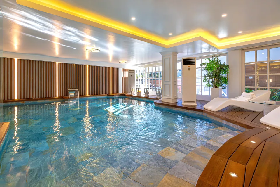 Fotografía de alquiler vacacional de una lujosa piscina interior con tumbonas y luz natural en Marbella
