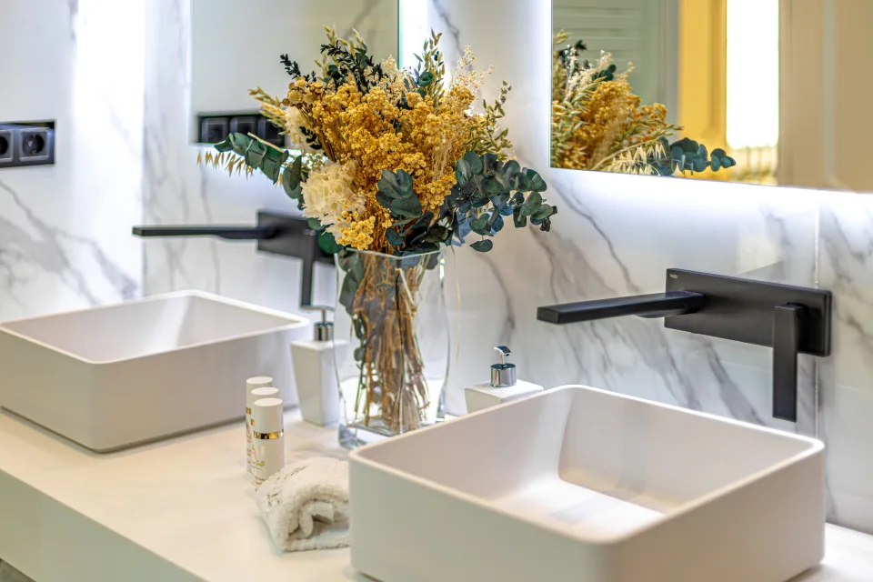 Fotografía de alquiler vacacional de un elegante baño con espejos iluminados y lavabos modernos en Marbella