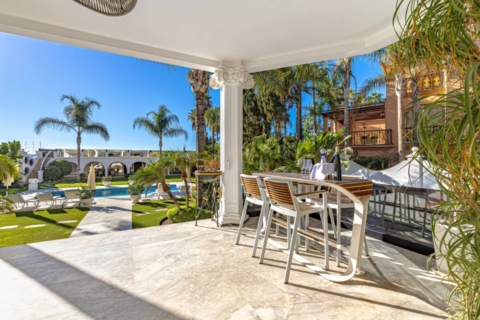 Fotografía de alquiler vacacional de un porche con barra de desayuno, vistas al jardín y la piscina en Marbella
