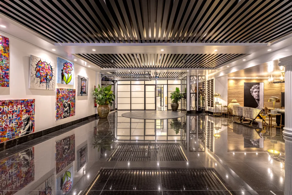 Fotografía de alquiler vacacional de un hall de entrada moderno con arte contemporáneo y suelo de mármol brillante en Marbella
