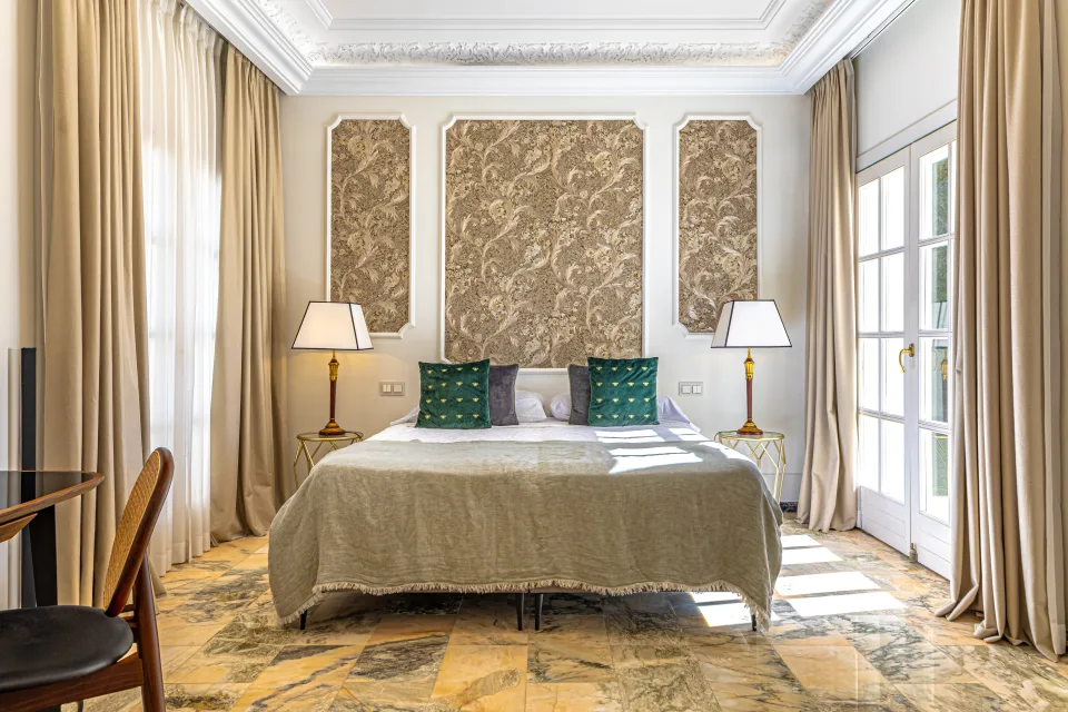 Fotografía de alquiler vacacional de un dormitorio luminoso con cama amplia, cabeceros empotrados y ventanas con acceso al exterior en Marbella