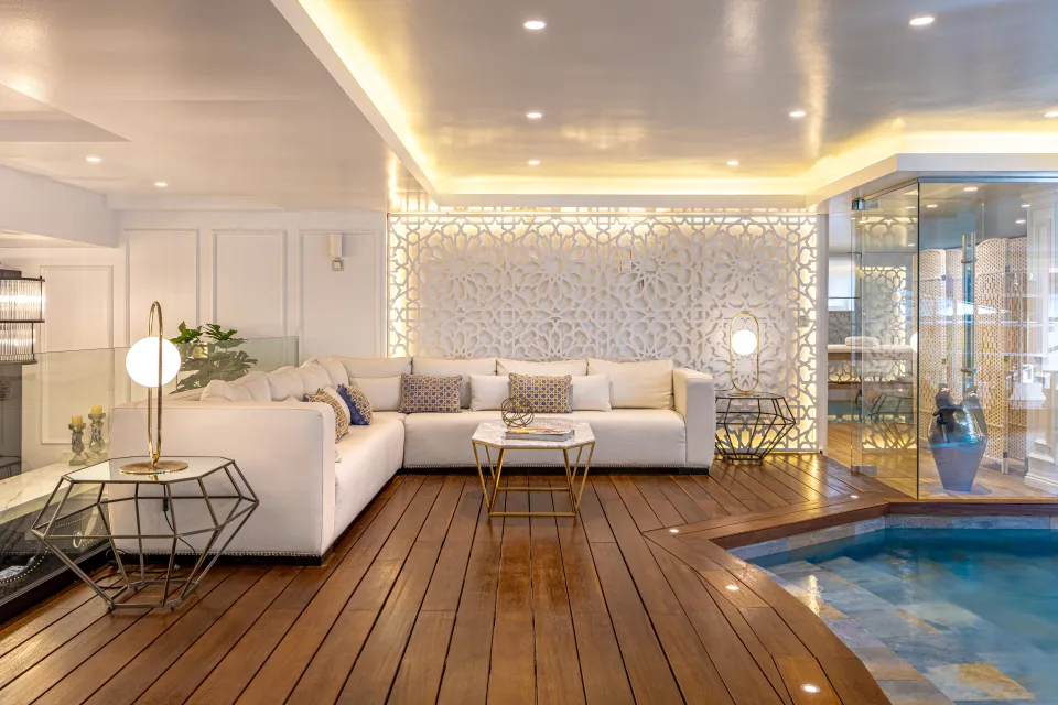 Fotografía de alquiler vacacional de un elegante salón con sofá blanco, mesas de centro doradas y acceso a una piscina en Marbella