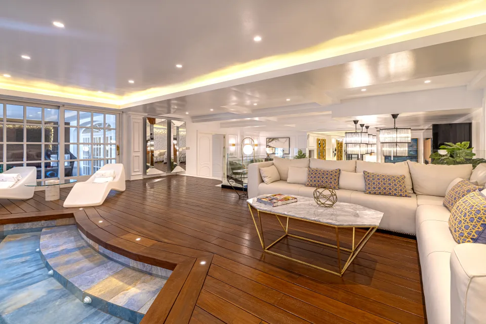 Fotografía de alquiler vacacional de un elegante salón con sofá claro, mesa de mármol y acceso a una piscina en Marbella