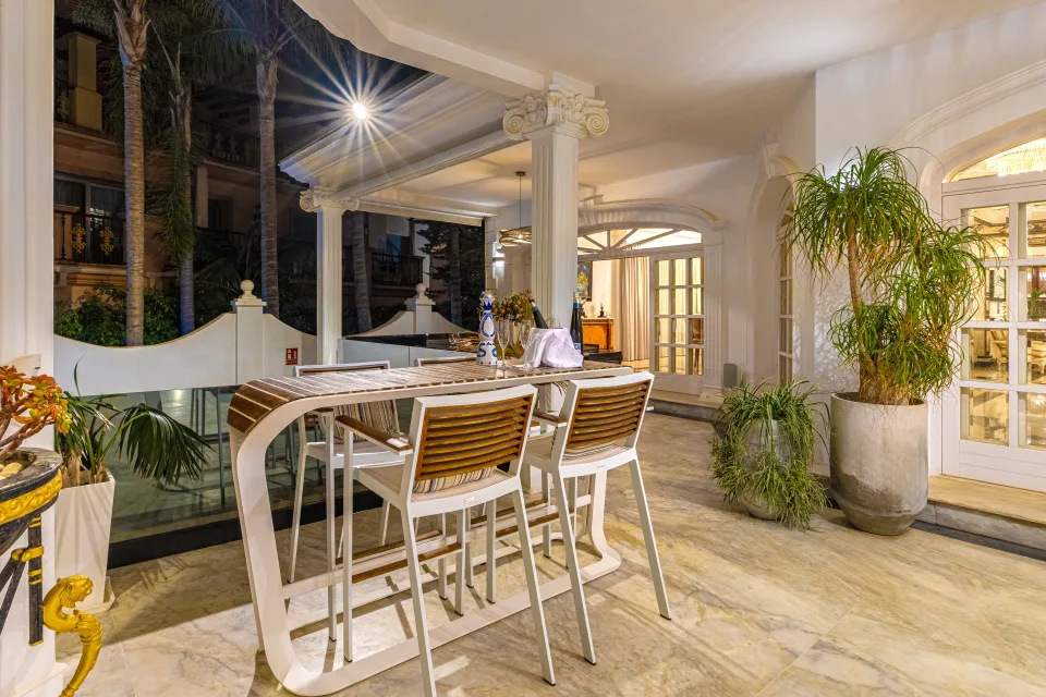 Fotografía de alquiler vacacional de una terraza con barandas de cristal, muebles modernos y plantas decorativas en Marbella