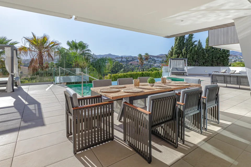Fotografía de interiorismo y arquitectura de una moderna terraza con muebles de exterior, mesa de comedor de madera en Estepona