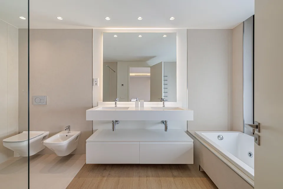 Fotografía de interiorismo y arquitectura de un baño moderno con lavabo doble, bañera de hidromasaje y revestimientos suaves en Estepona