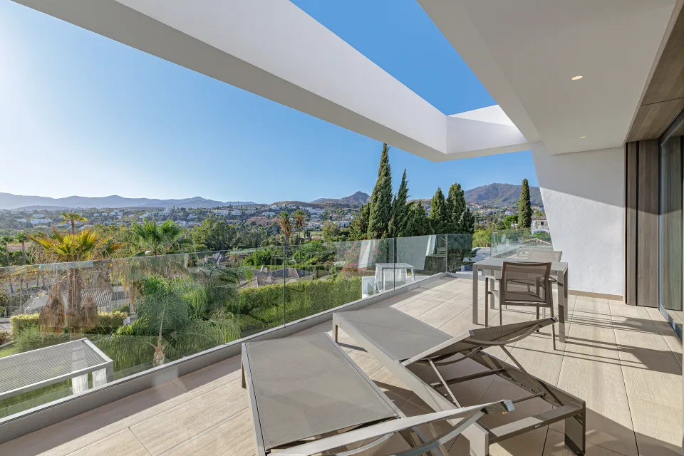 Fotografía de interiorismo y arquitectura de una terraza moderna con tumbonas y vistas panorámicas a la montaña en Estepona