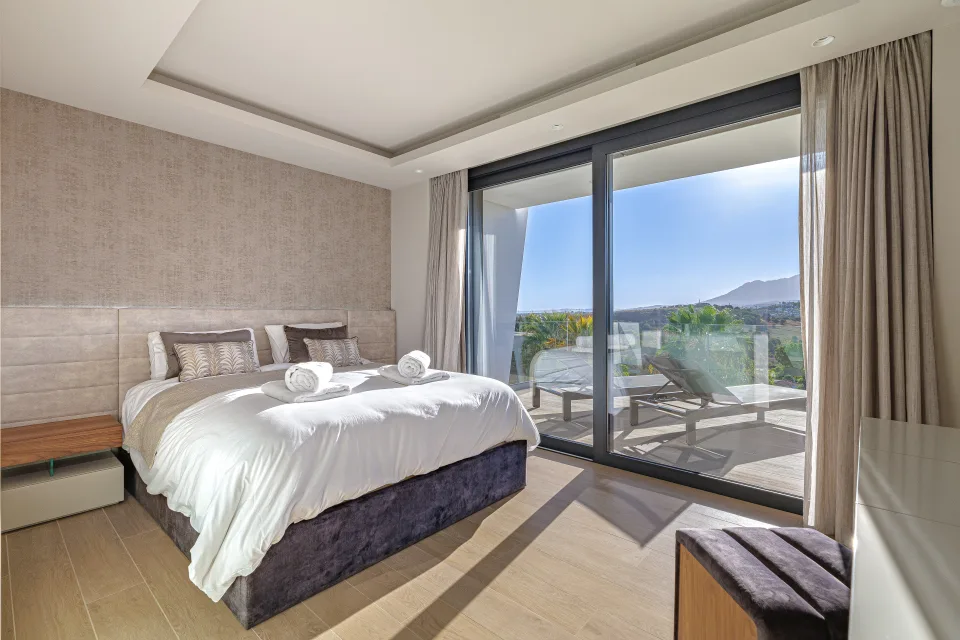 Fotografía de interiorismo y arquitectura de un elegante dormitorio con cama doble, decoración en tonos neutros en Estepona