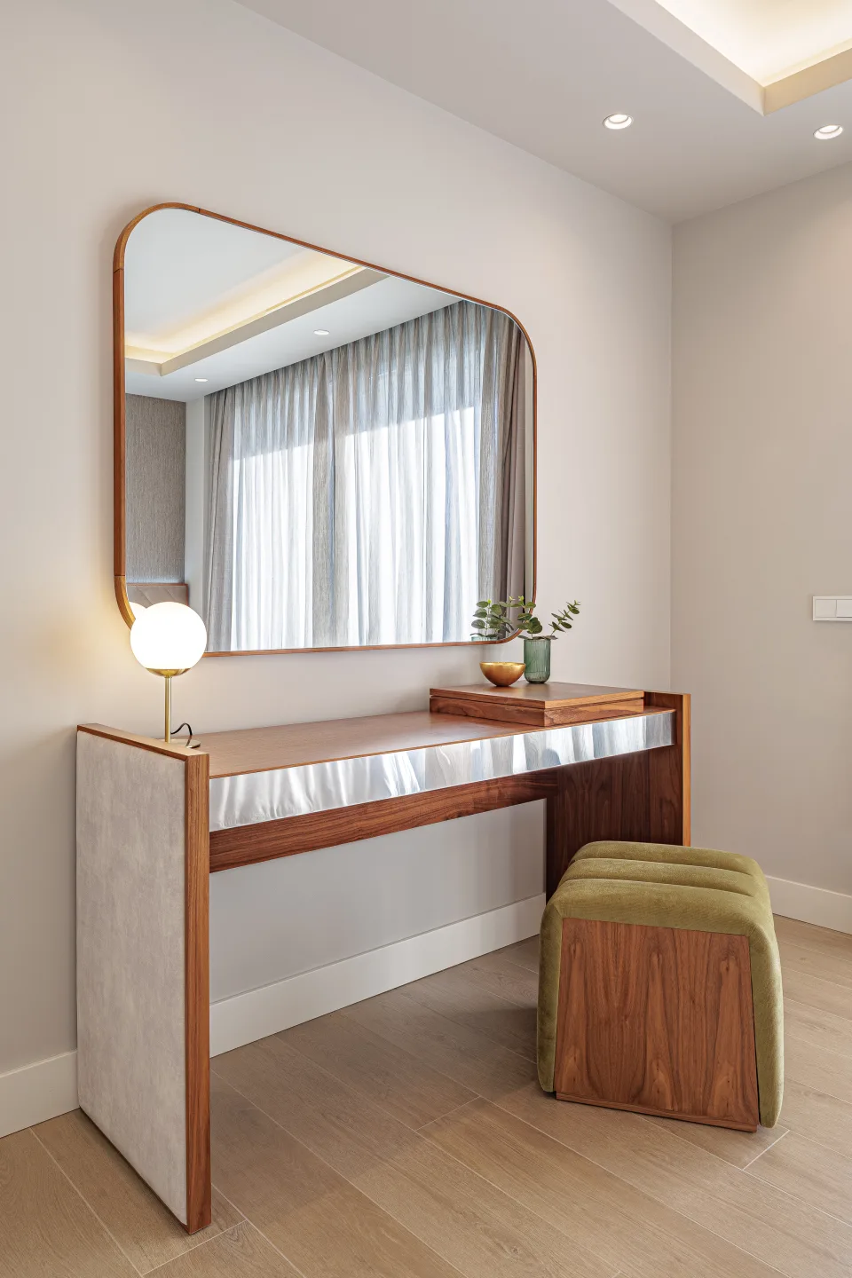 Fotografía de interiorismo y arquitectura de un elegante tocador de madera con espejo y taburete acolchado en tonos suaves en Estepona | Villa de 4M€ en El Paraíso