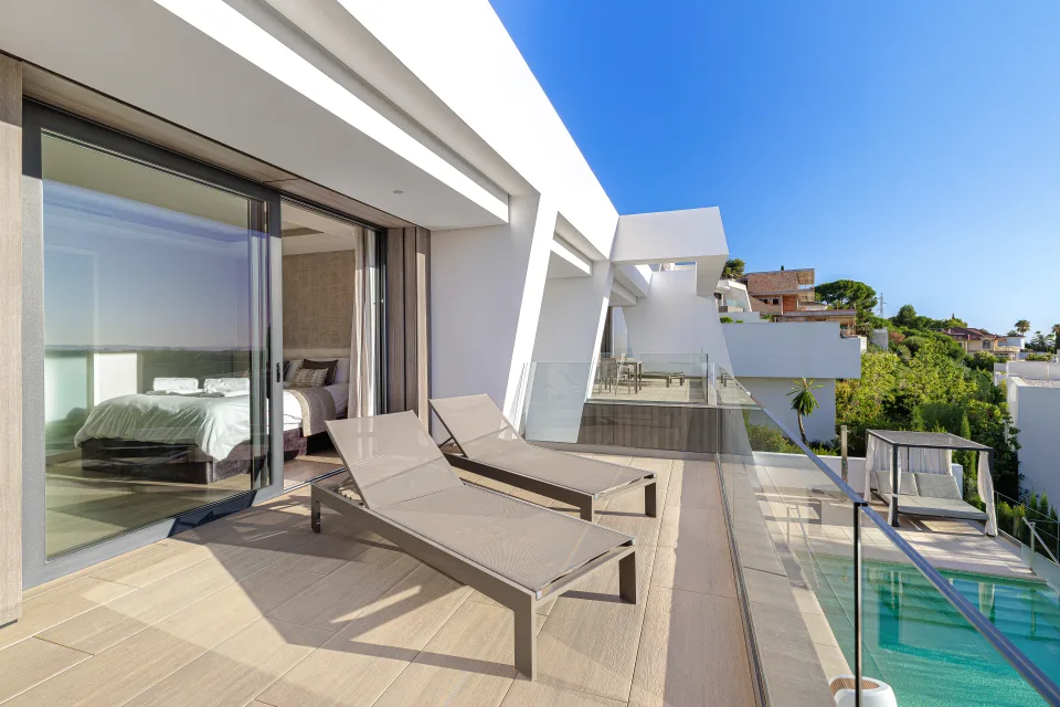 Fotografía de interiorismo y arquitectura de una moderna terraza con tumbonas, piscina y vistas despejadas en Estepona