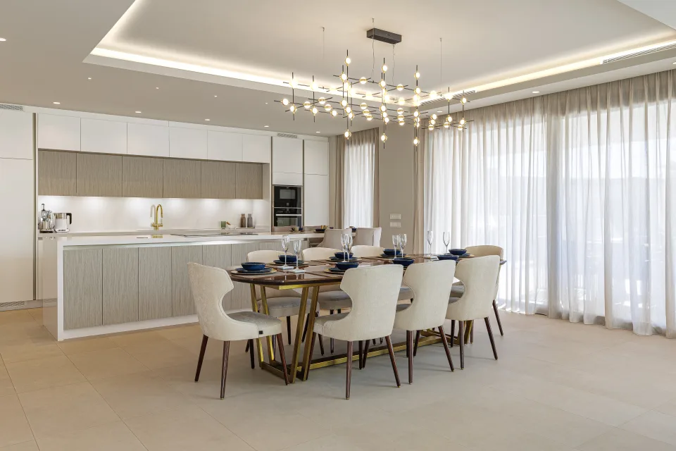 Interior design and architecture photograph of a modern dining area with golden tables and light fabric chairs in Estepona