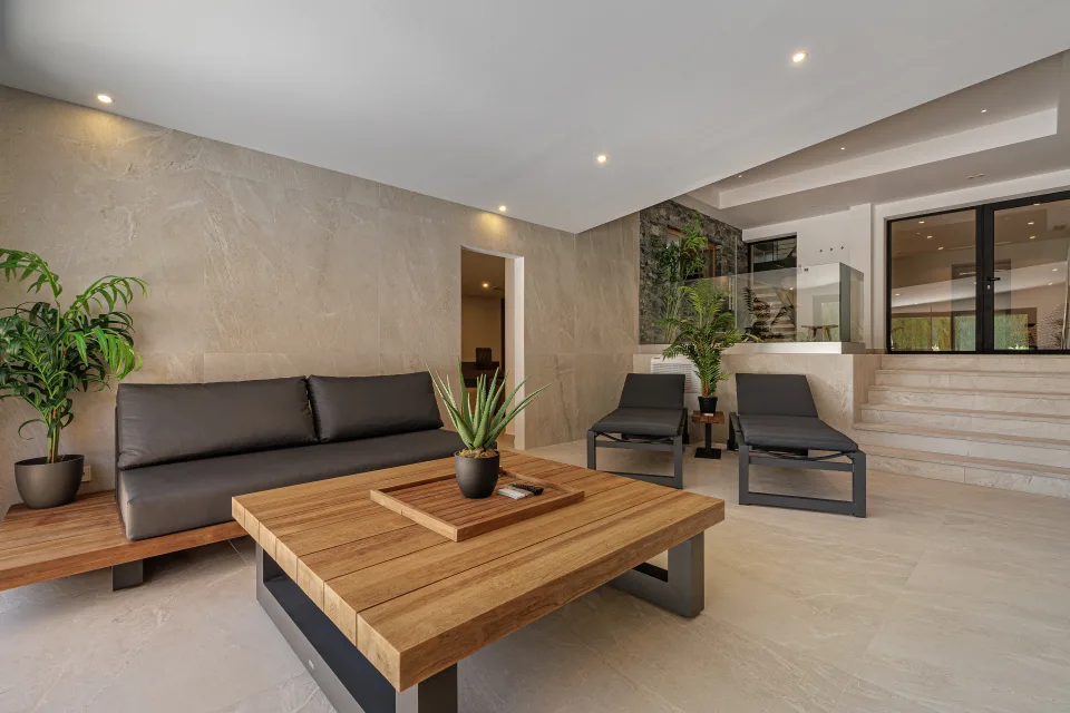 Interior design and architecture photograph of a stylish living area with dark sofa, wooden table and abundant natural light in Estepona