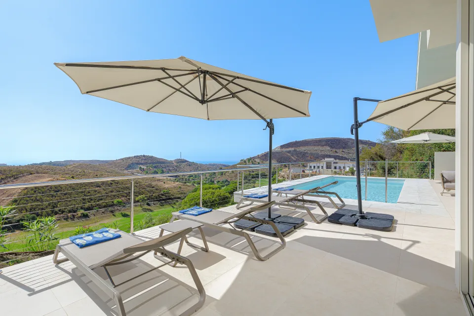 Vacation rental photograph of a terrace with sun loungers, umbrellas and sea views in Benahavís