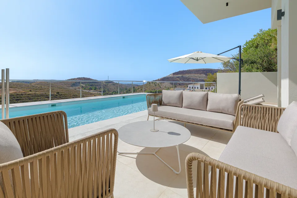 Vacation rental photograph of a stylish outdoor area featuring wicker sofas, a round table in Benahavís