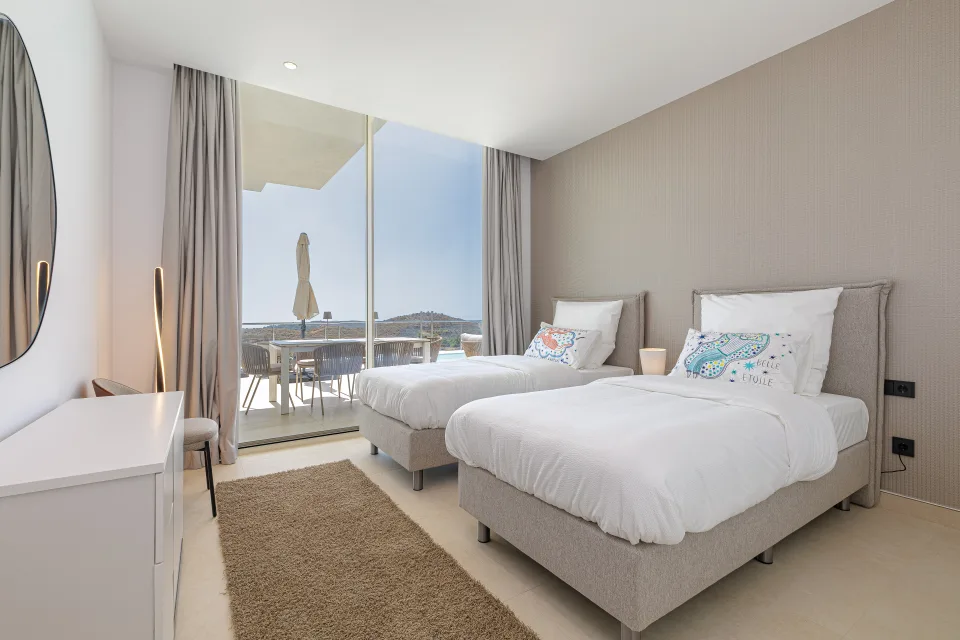 Vacation rental photograph of a bright bedroom with two single beds, wardrobe and access to terrace with views in Benahavís