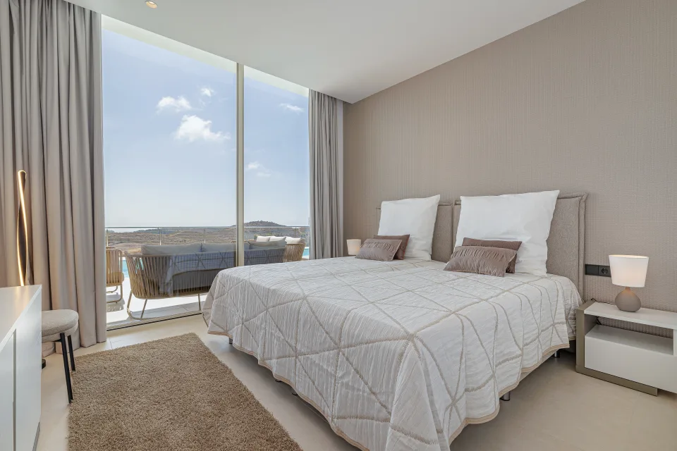 Vacation rental photograph of a bright bedroom with two single beds, neutral decor and access to a terrace with views in Benahavís