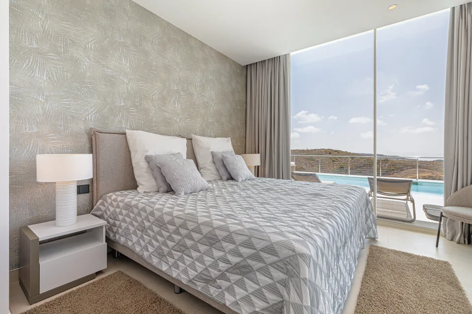 Vacation rental photograph of a modern bedroom with a double bed, natural light and access to a terrace with views in Benahavís