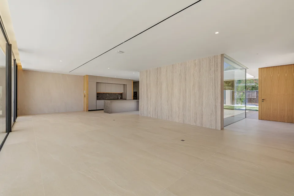 Fotografía de arquitectura de un amplio salón luminoso con grandes ventanales, vistas al jardín en Sotogrande
