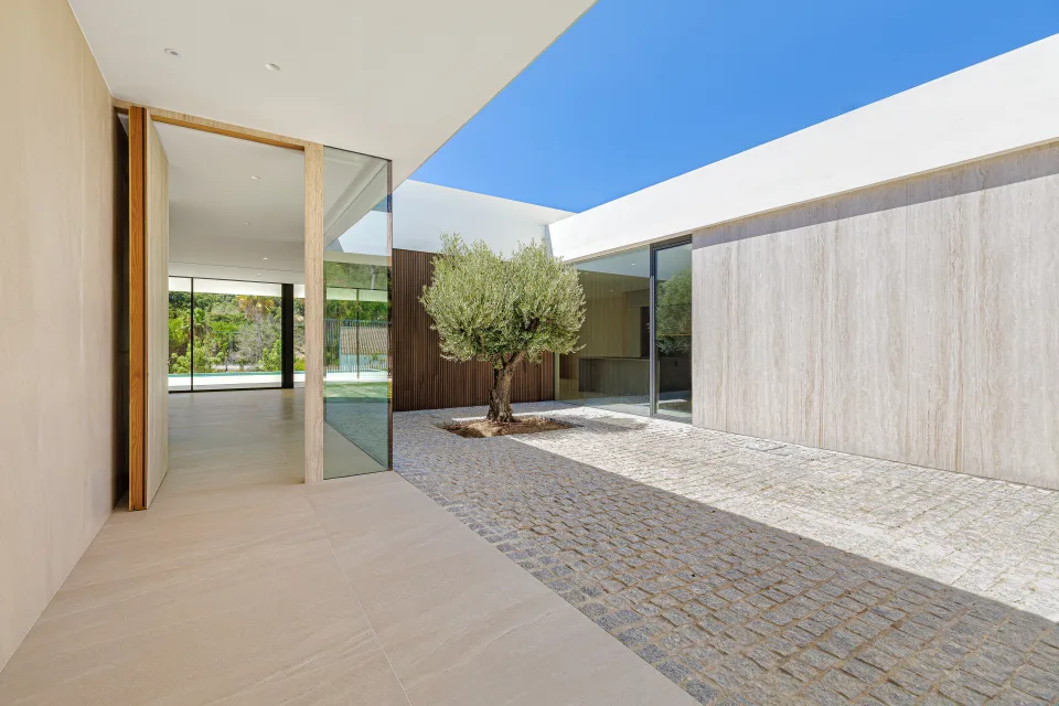 Architectural photograph of a courtyard featuring an olive tree, stone walls in Sotogrande