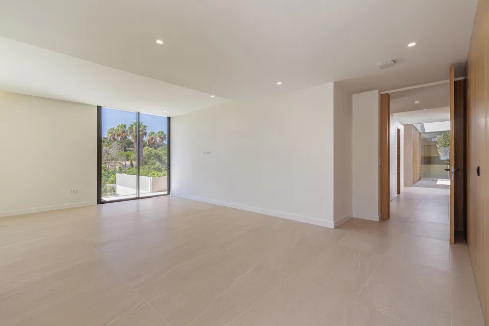 Architectural photograph of a bright living room with large windows and light stone flooring in Sotogrande
