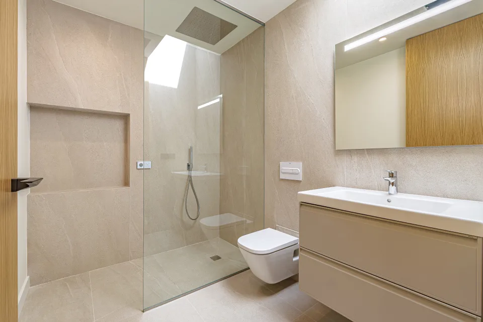 Architectural photograph of a modern bathroom with walk-in shower, integrated sink and neutral tone walls in Sotogrande