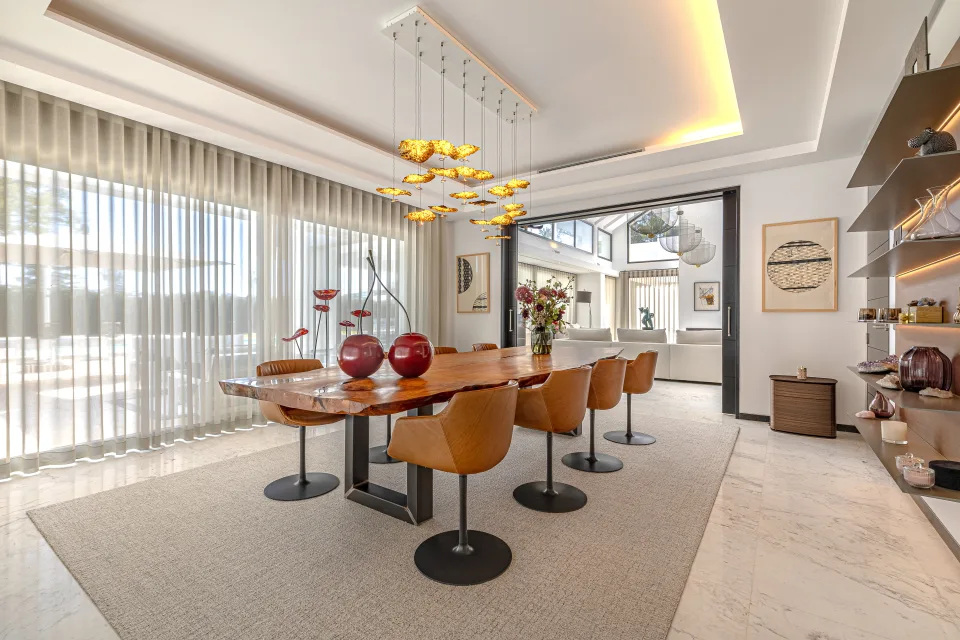 Interior design and architecture photograph of an elegant dining room with a wooden table, leather chairs in Guadalmina Baja