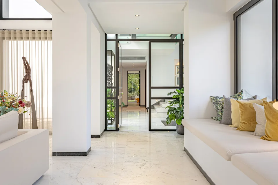 Interior design and architecture photograph of a spacious foyer with marble flooring, white walls and modern decor in Guadalmina Baja