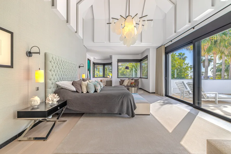 Interior design and architecture photograph of a spacious bedroom with a King size bed, large windows allowing natural light in Guadalmina Baja