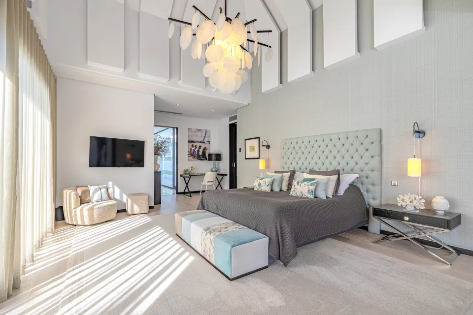 Interior design and architecture photograph of a spacious bedroom with a king-size bed, upholstered headboard in Guadalmina Baja
