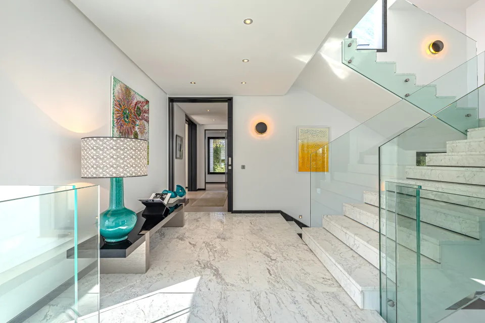 Interior design and architecture photograph of a bright hallway with marble stairs and decorative details in Guadalmina Baja