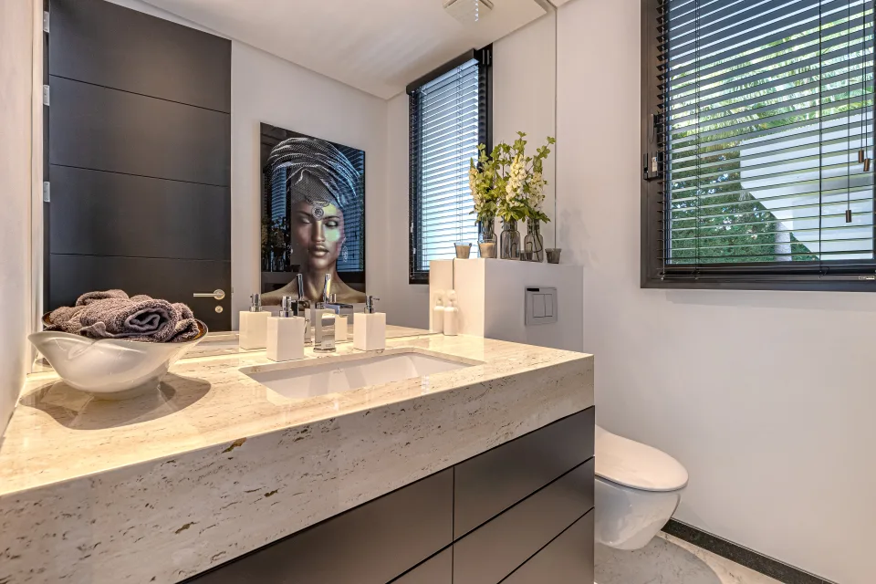 Interior design and architecture photograph of a modern bathroom with stone sink, large mirror and minimalist decor in Guadalmina Baja