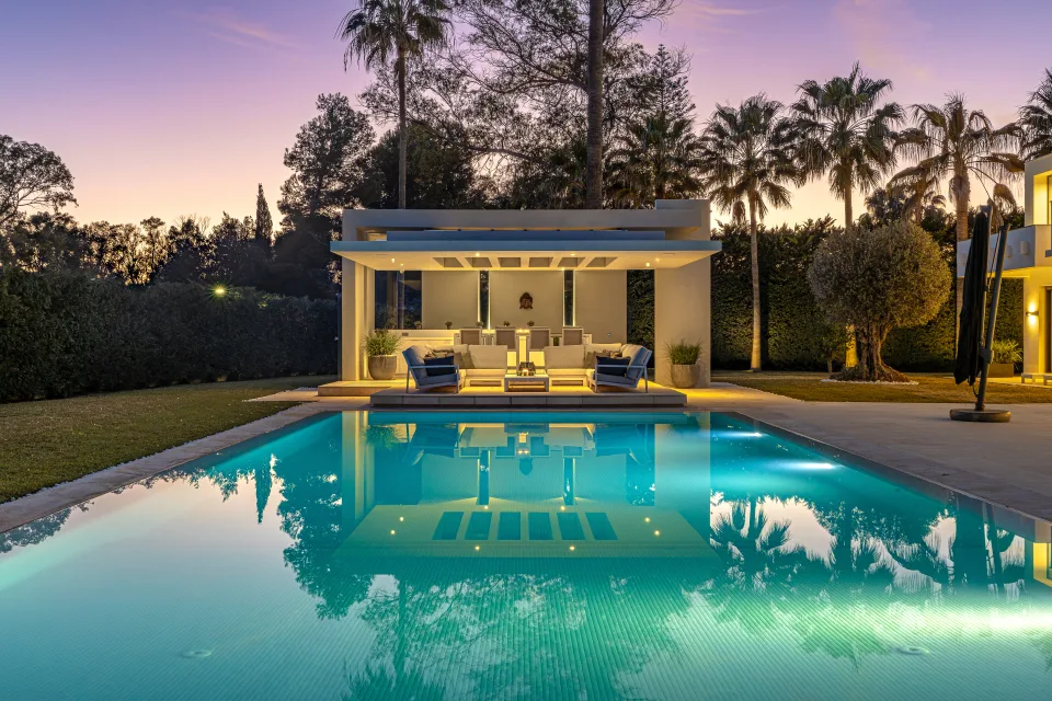 Interior design and architecture photograph of a stylish outdoor space with a swimming pool, seating area in Guadalmina Baja